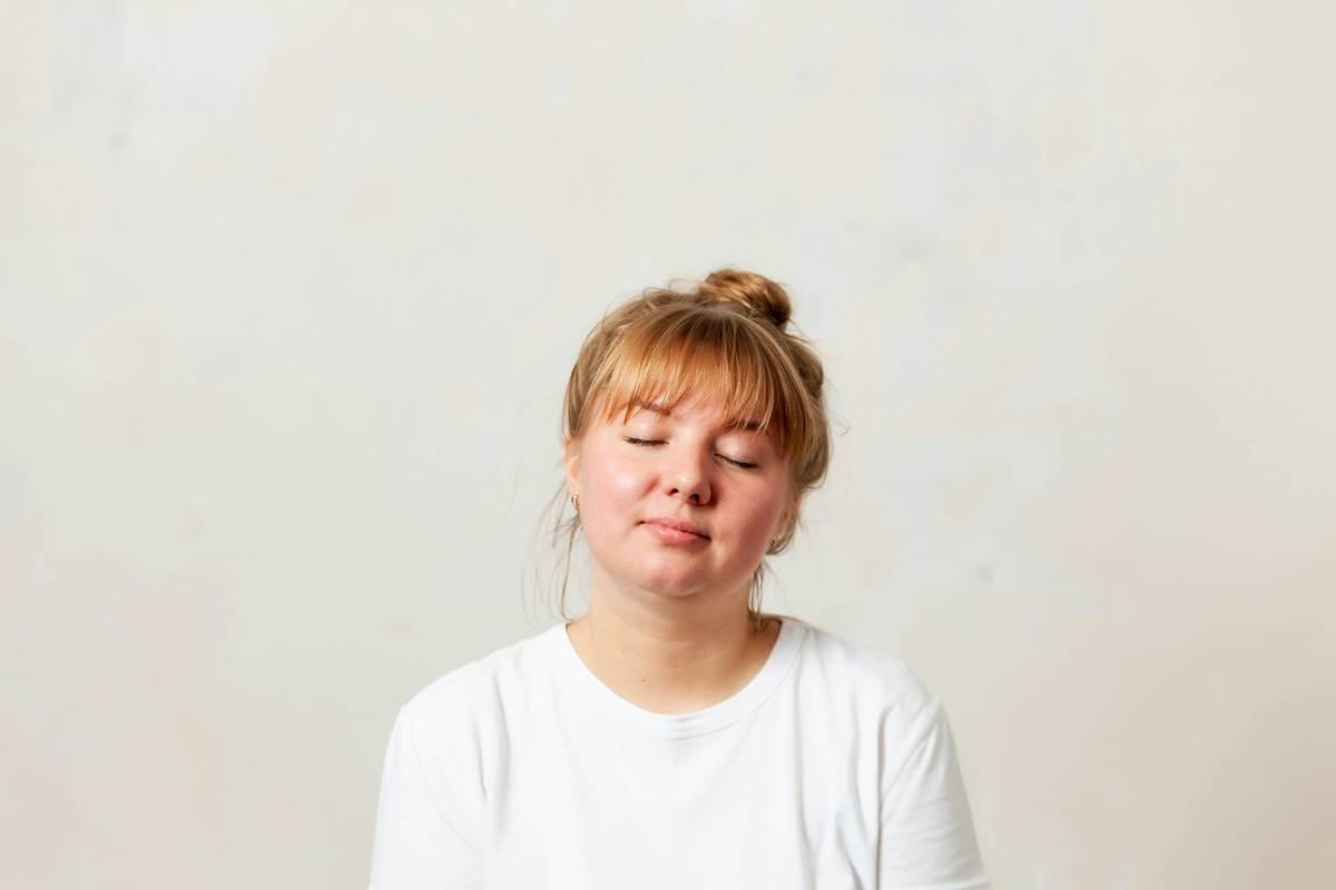 Self-Hypnosis: woman meditating with headphones while journaling healthy food choices